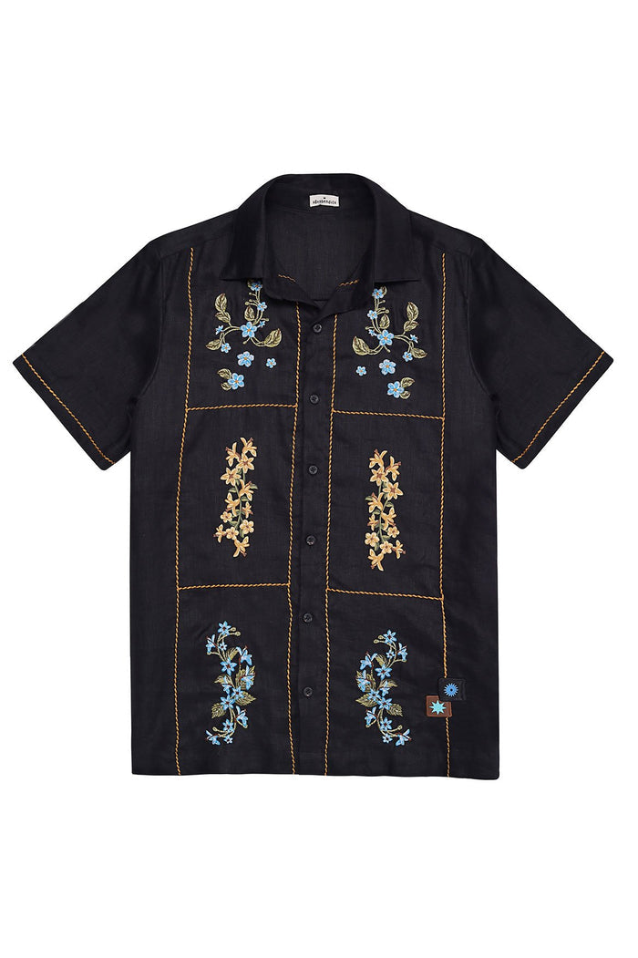 Black short-sleeve button-up shirt with gold rope stitching forming grid panels and embroidered floral clusters in blue and tan