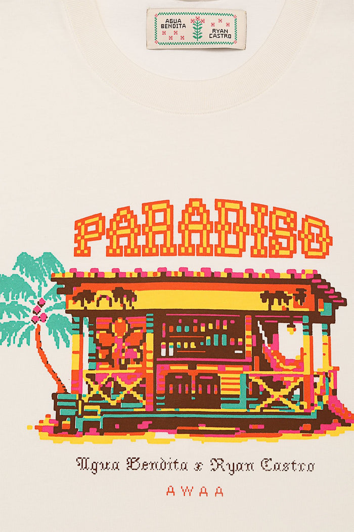 Cream t-shirt with pixelated embroidered graphic depicting paradise scene with palm trees, tropical structure, and colorful geometric details