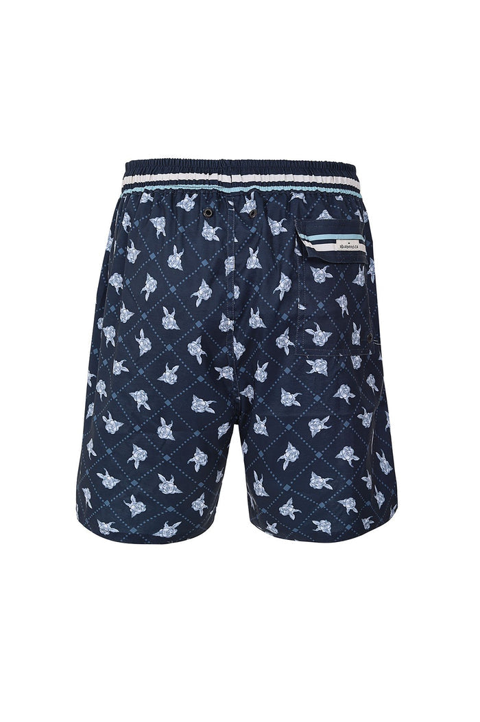 Navy swim trunks with diagonal lattice pattern and light blue turtle print, elastic waistband with white stripes, back pocket