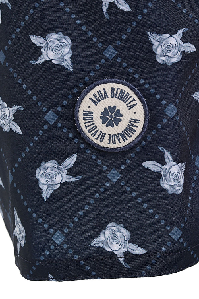 Navy swim trunks with light blue rose print, dotted geometric pattern, and circular branded emblem at center