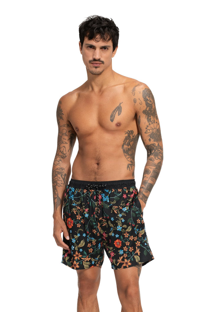 Black swim trunks with all-over floral print in blue, red, orange, and green with elastic waistband