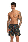 Black swim trunks with all-over floral print in blue, red, orange, and green with elastic waistband