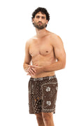 Brown swim trunks with cream pattern detail print and geometric details along sides and waistband