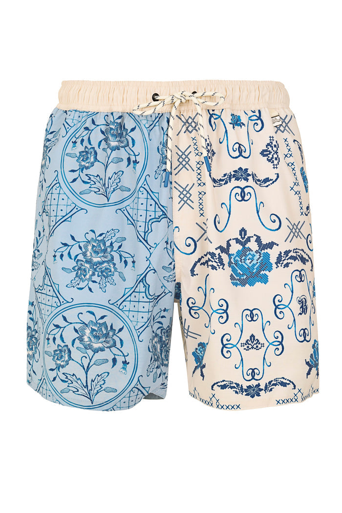Men's swim trunks with split design: left leg in light blue with circular pattern detail print, right leg in cream with blue embroidered scrollwork a…