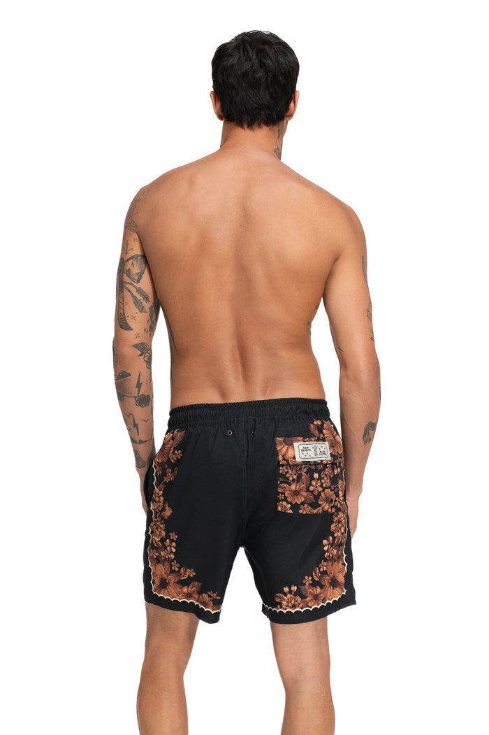 Black swim trunks with coral pattern detail embroidery along sides and hem, back view with elastic waistband and rear pocket