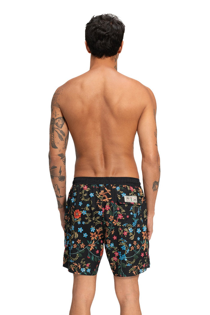 Black swim trunks with all-over multicolor floral print, back view