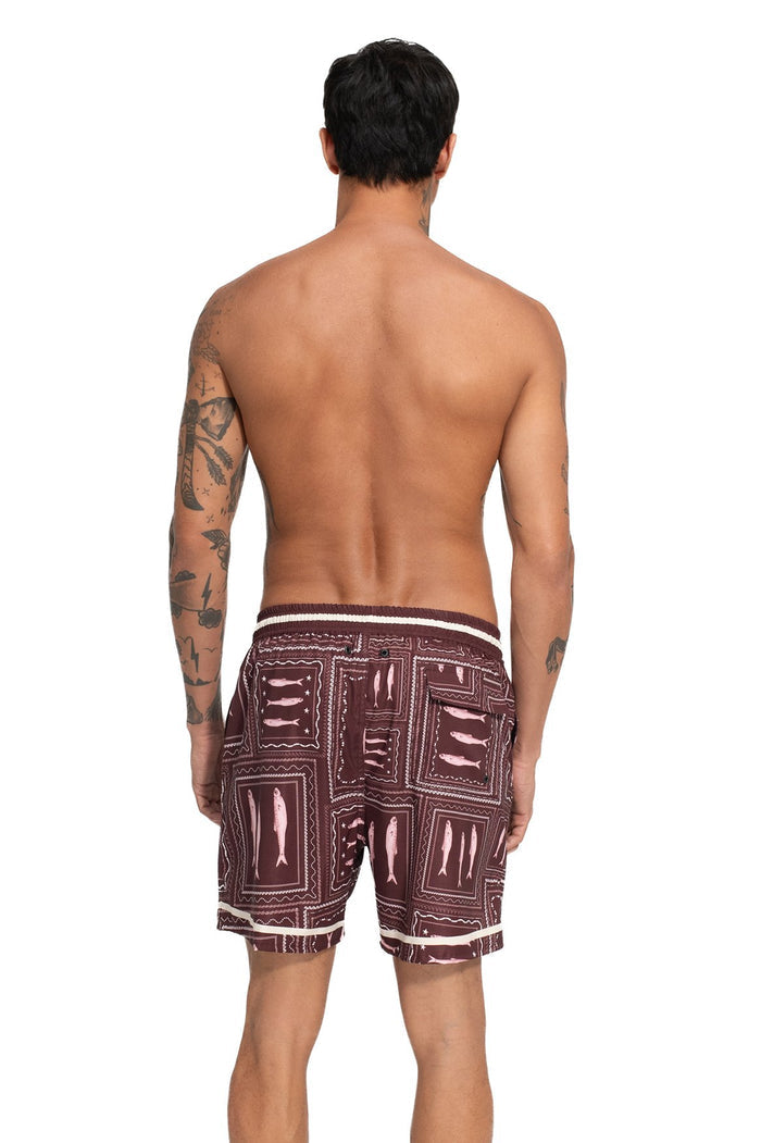 Men's swim trunks in burgundy with geometric grid print featuring rectangular panels and contrast white striped waistband, back view