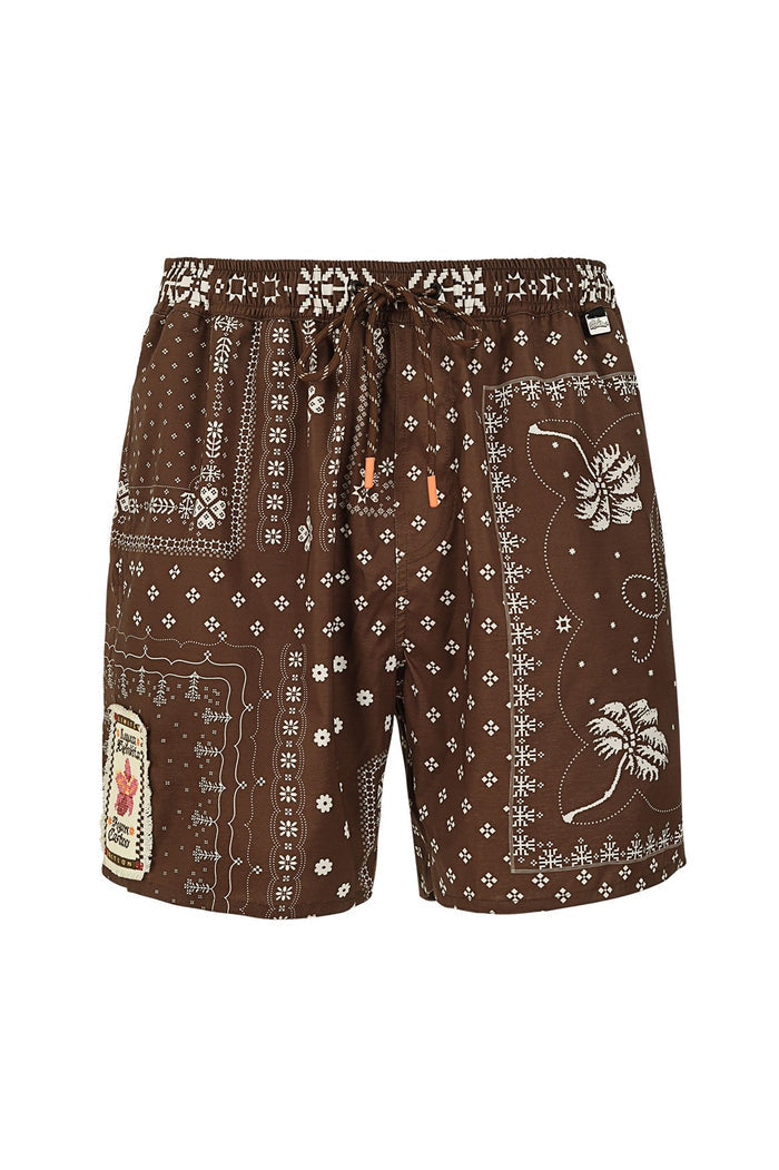 Brown swim trunks with white geometric patterns, small flowers, palm trees, and decorative patches on sides and hem