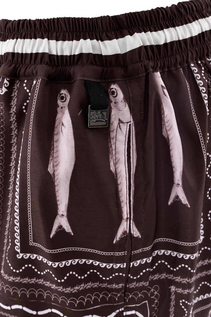 Brown swim trunks with pattern detail print, white striped waistband, and embroidered wave details