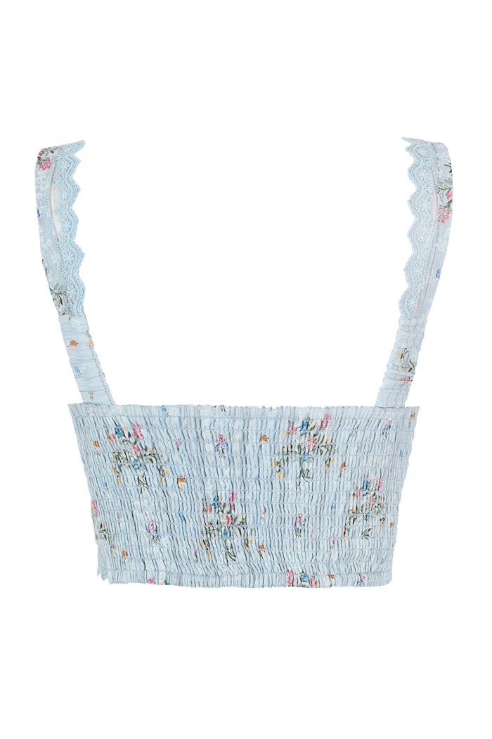 Light blue smocked crop top with lace-trimmed ruffled straps and scattered pattern detail embroidery throughout