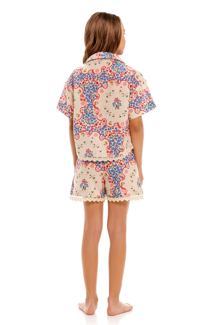 Laya Kids Shorts in cream with blue and coral pattern detail print, lace trim, and elastic waist, back view