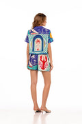 Lia Shorts in multicolor placement print with arched frames, palm trees, lobster, striped borders, and coastal graphics on blue and turquoise base