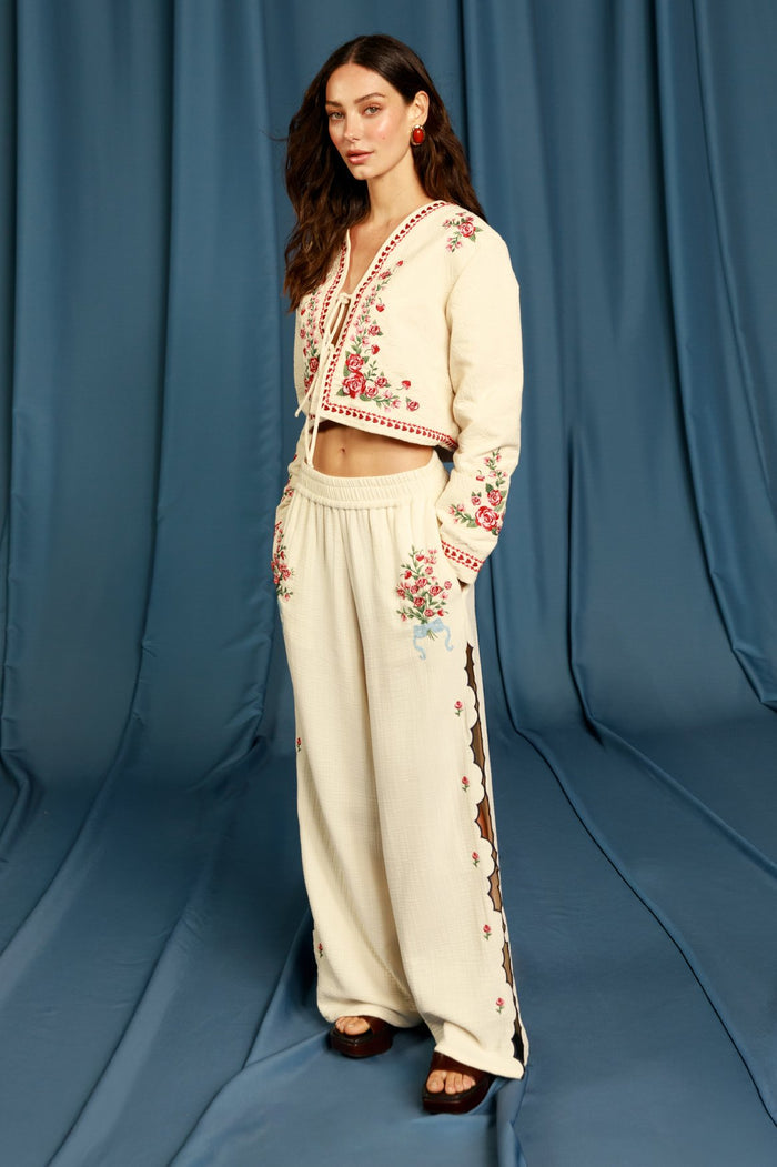 Cream wide-leg pants with embroidered pattern detail details and scalloped laser-cut side panels with brown trim