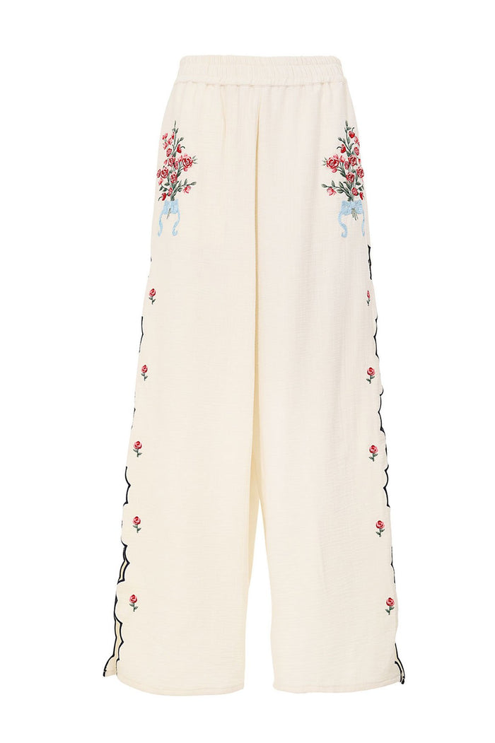 Cream wide-leg pants with embroidered pattern detail bouquets at hips, laser-cut scalloped sides with scattered rose embroidery