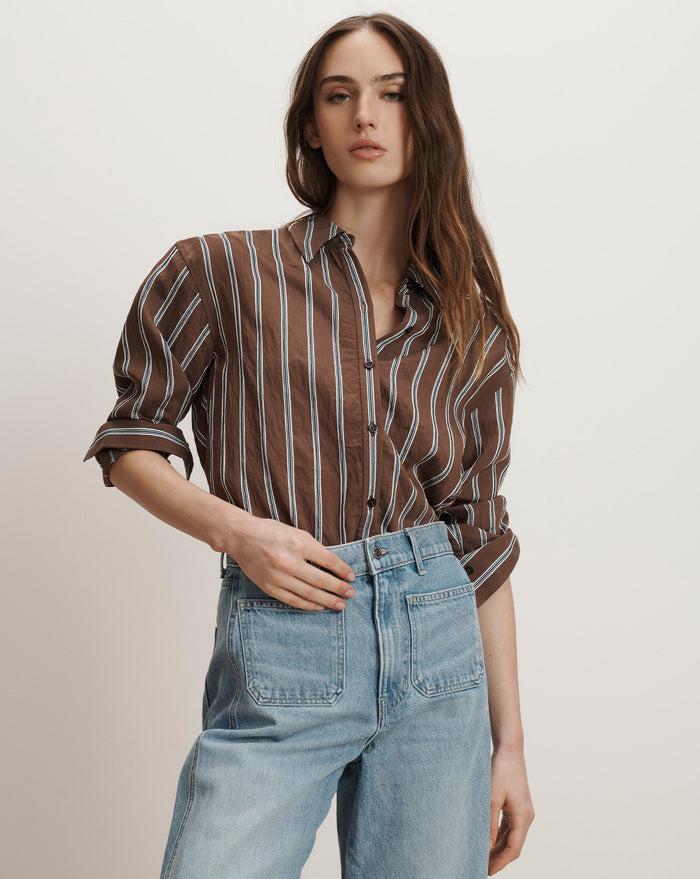 Veronica Beard Brown and white striped button-down shirt with rolled sleeves, paired with light wash denim jeans.