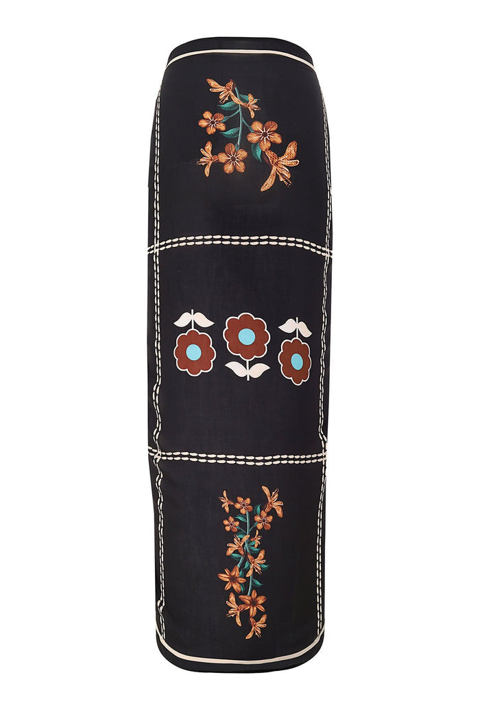 Black rectangular pareo with white contrast stitching, embroidered pattern detail clusters in orange and teal, and appliqué flowers in brown and turq…