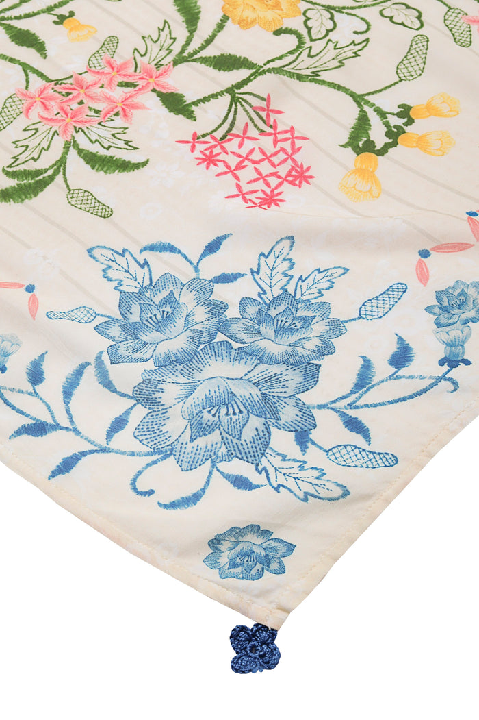 White pareo with multicolor embroidered pattern detail details in blue, pink, yellow, and green, featuring handmade crochet trim at corner