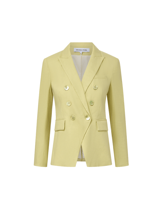 Veronica Beard Light green double-breasted blazer with peak lapels, paired with a white button-down shirt and off-white trousers.