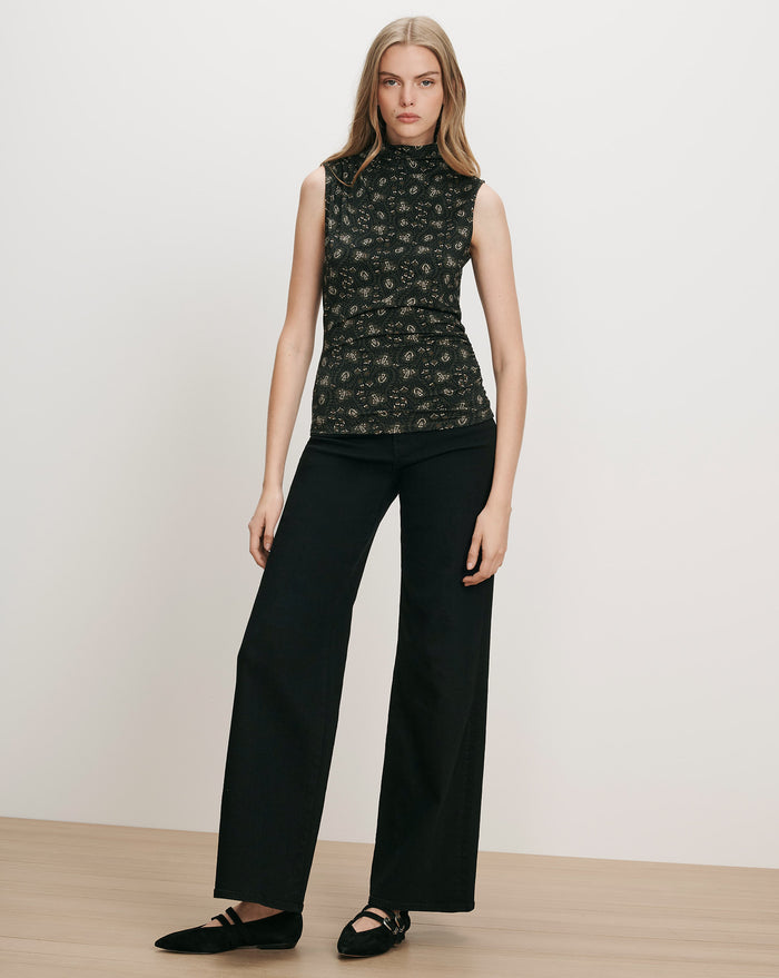 Veronica Beard Black floral sleeveless mock neck top and black wide-leg pants.