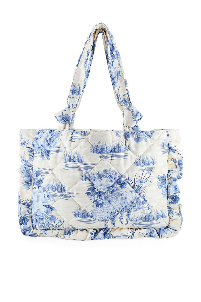 Quilted tote bag in cream with blue pattern detail and wave print, knotted fabric handles, and ruffle trim edges
