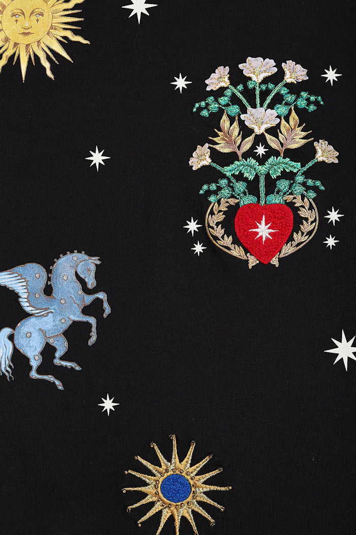 Black t-shirt with embroidered celestial design featuring sun, stars, blue winged horse, red heart with florals, and gold emblem details