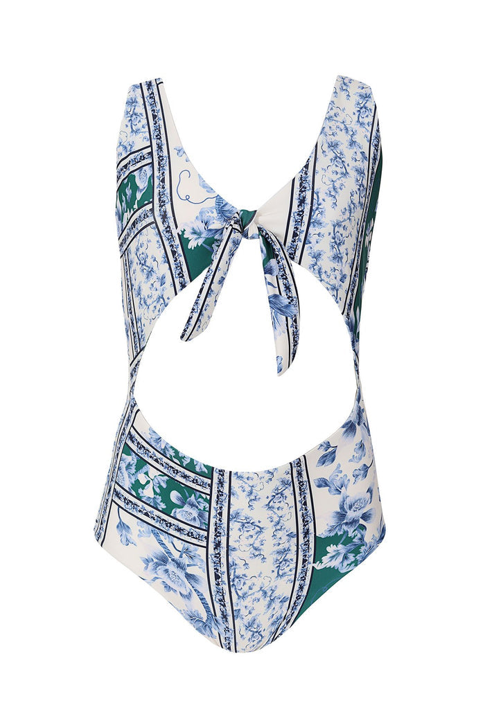 White one-piece swimsuit with blue pattern detail print, green panels, and decorative stripes, featuring front tie detail and cutout waist