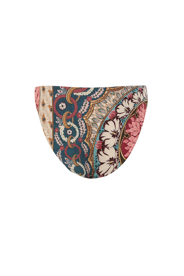 Reversible bikini bottom with vertical bands featuring peacock feather pattern, pattern detail medallions in teal and coral, and geometric prints in…