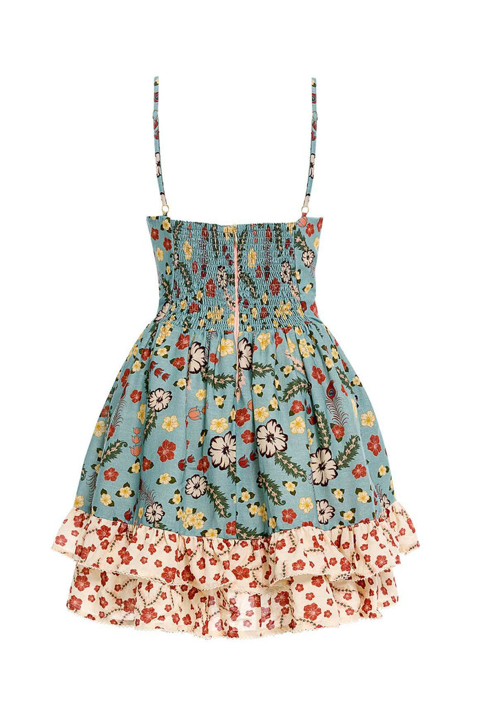 Nader Isadora mini dress in dusty blue with floral print, smocked bodice, adjustable straps, and cream ruffle hem with red floral detail