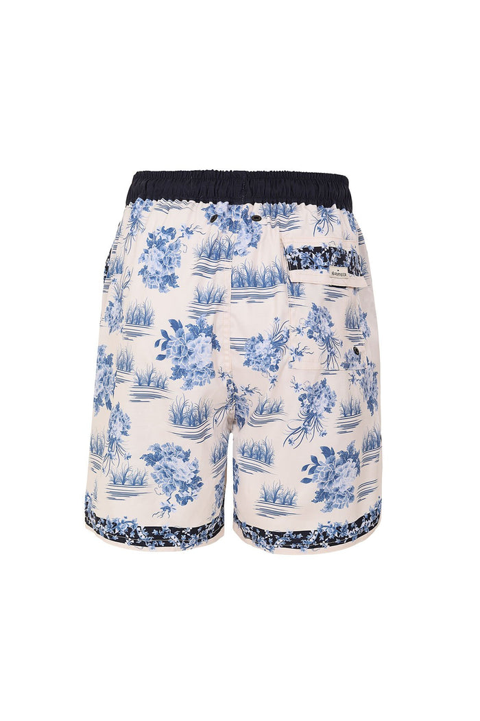 Nader Joe Men's Swim Trunks in cream with blue pattern detail and botanical print, navy elastic waistband, and contrast pattern detail trim at hem