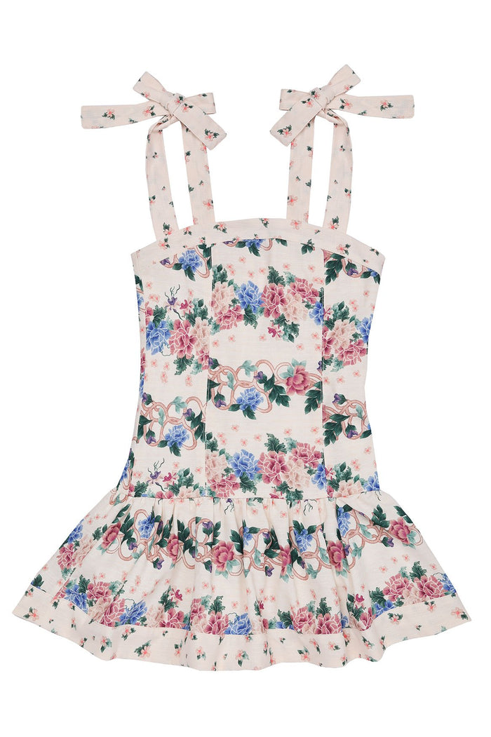 Nader Kaio kids' dress in cream with pink, blue, and green floral print, adjustable shoulder ties with bows, and ruffled hem with decorative trim