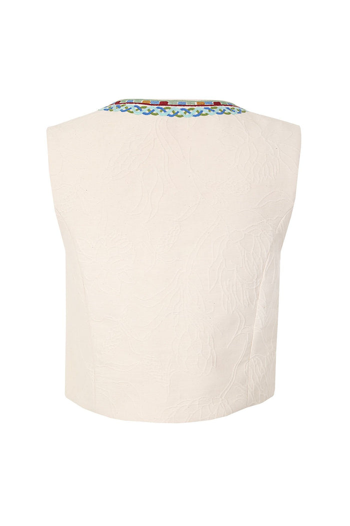 Cream textured vest with multicolored embroidered geometric trim at neckline featuring blue, green, yellow, and red details