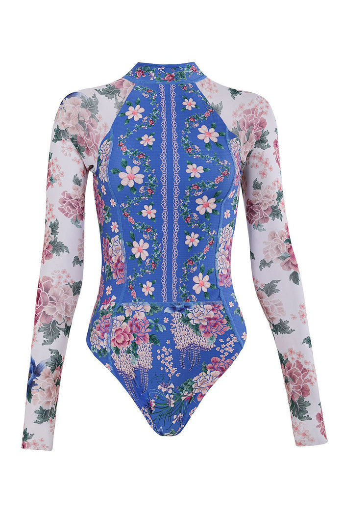 Long-sleeve one-piece swimsuit with front zipper, blue body featuring pattern detail print with pink blooms and white lace trim, sheer white mesh sle…