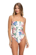 Nader Posh one-piece swimsuit with straight neckline, thin straps, and floral print in pink, blue, and green on white base with side lace-up ties