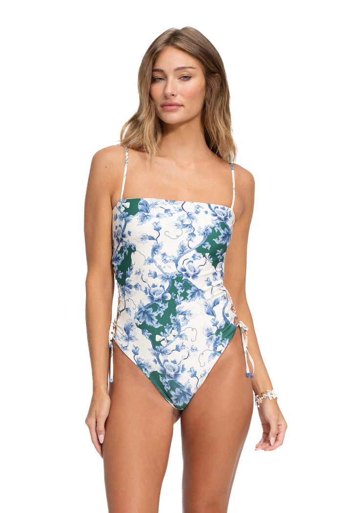 One-piece swimsuit with adjustable side ties, featuring blue and green floral print on white background