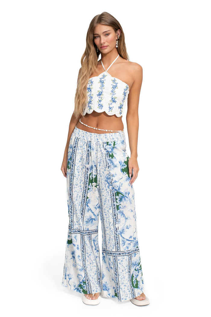 White halter crop top with scalloped hem and blue pattern detail embroidery in vertical stripes, paired with matching wide-leg pants