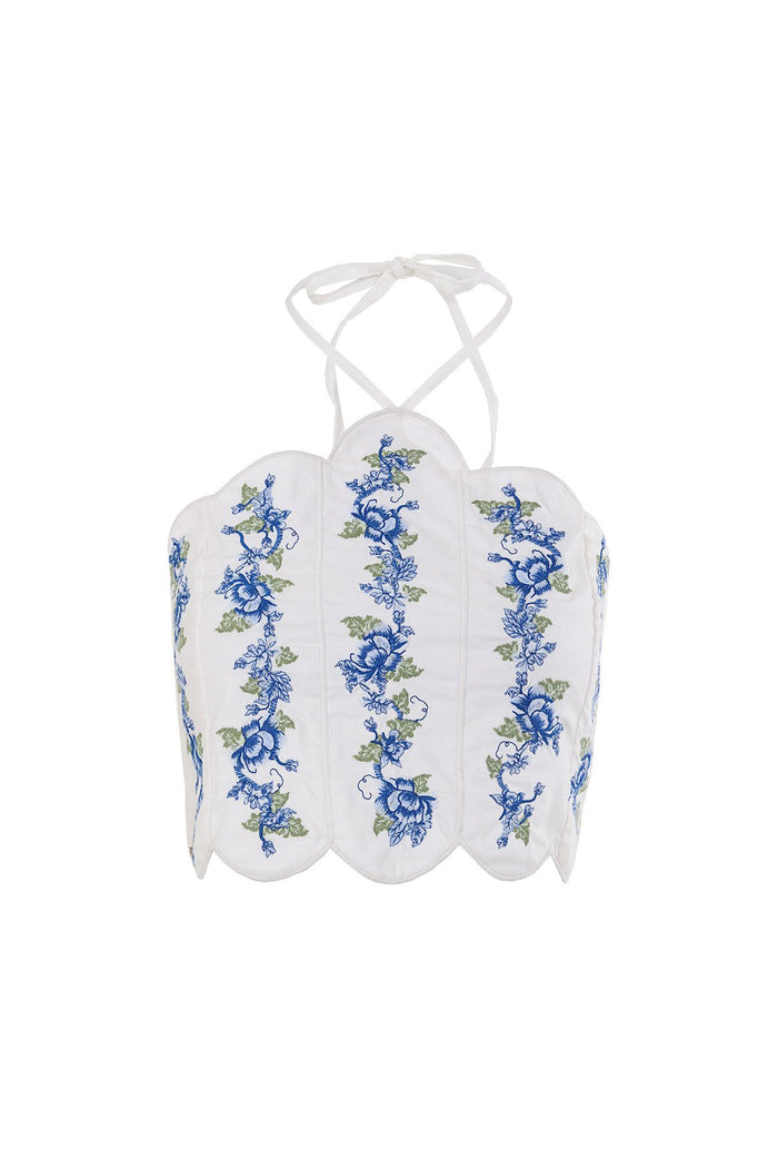 White halter crop top with scalloped edges and vertical blue pattern detail embroidery with green leaves