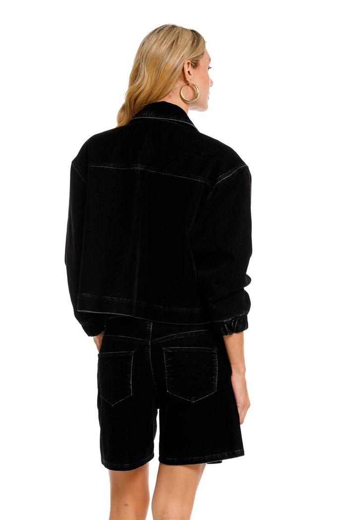 Black denim shorts with handmade floral embroidery, back view showing structured fit and pocket detail