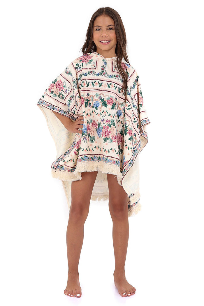 Cream kids' poncho towel with hood and fringe hem, featuring horizontal bands of pink and blue pattern detail print with decorative trim