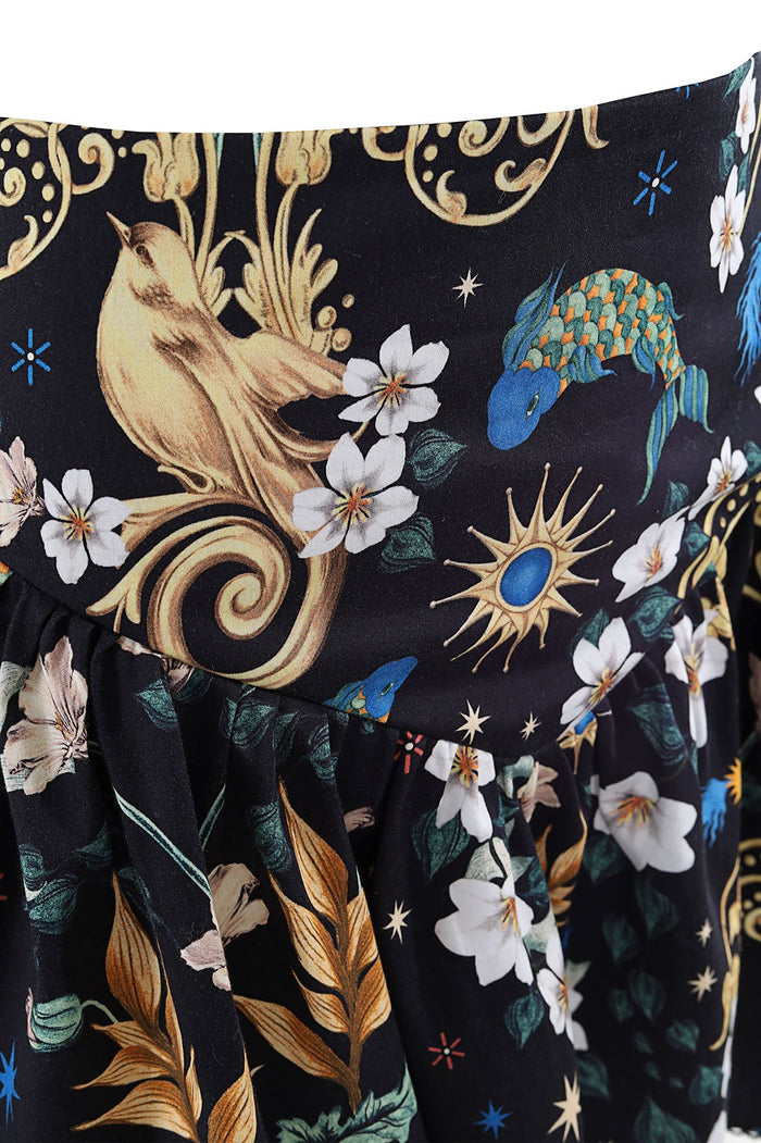 Black mini skirt with ornate print featuring gold baroque scrollwork, white florals, blue decorative birds, and celestial star accents