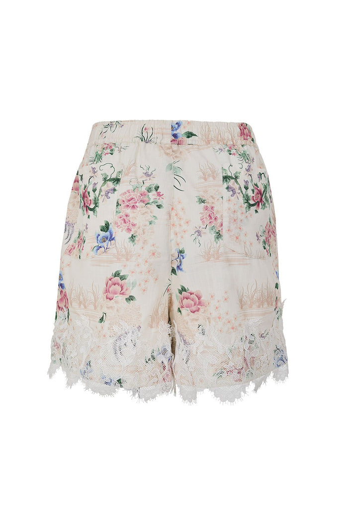 Nader Watts Shorts in cream with floral print featuring pink and blue blooms, grass details, and lace trim hem