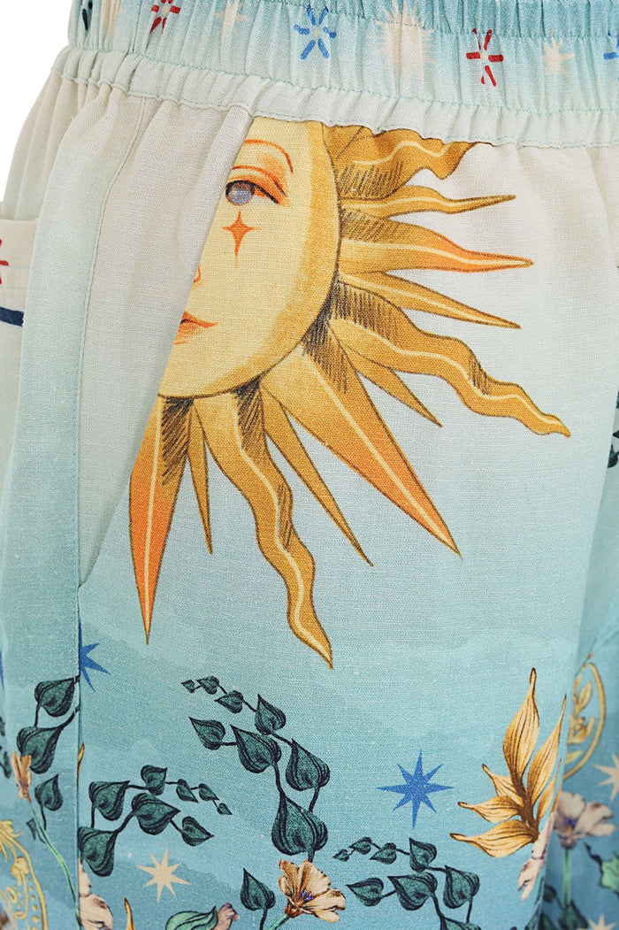 Light blue shorts with sun and botanical print, elastic waistband, and functional pockets