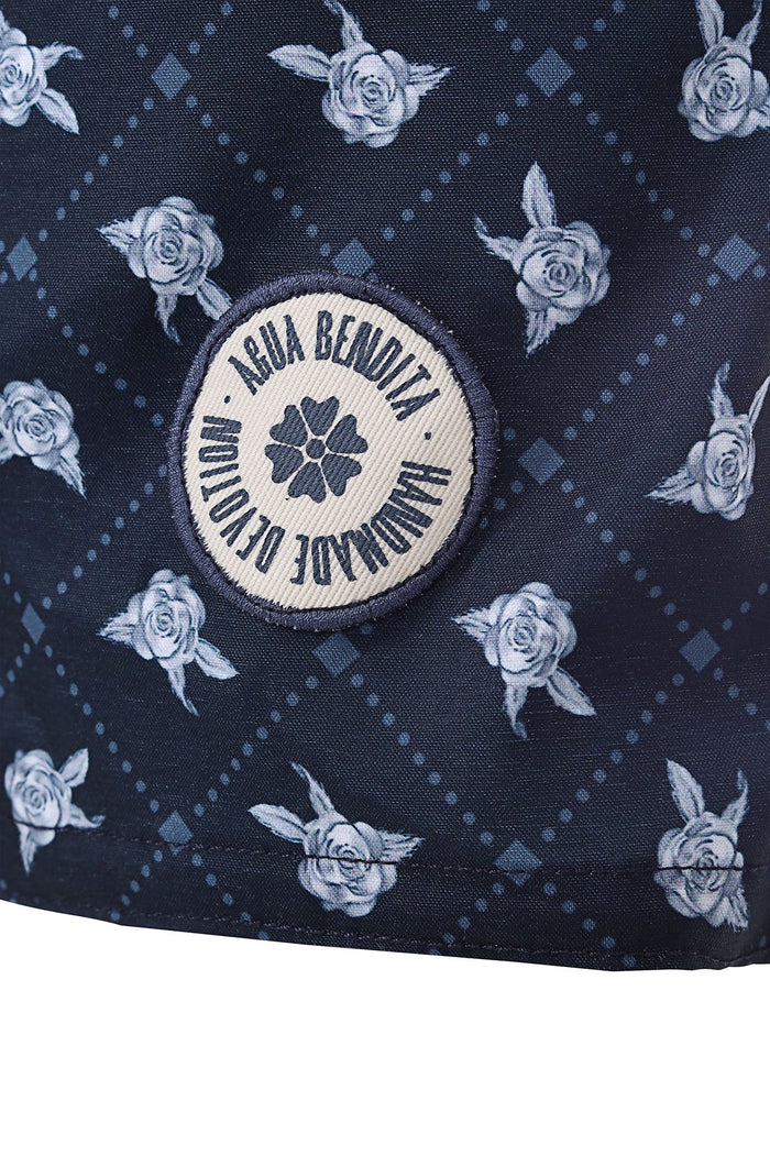 Navy swim trunks with light blue rose print and circular embroidered brand emblem