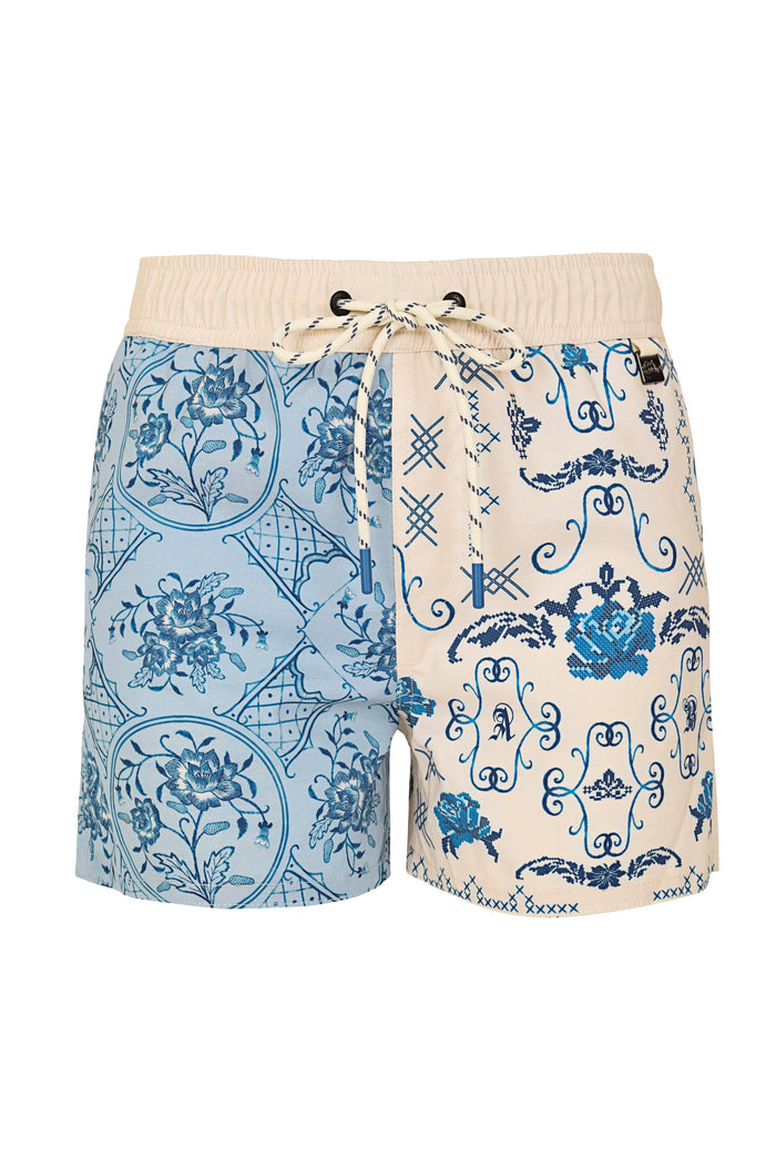Boys' swim trunks with split design featuring light blue tile pattern with pattern detail medallions on left side and cream ornamental scrollwork pat…