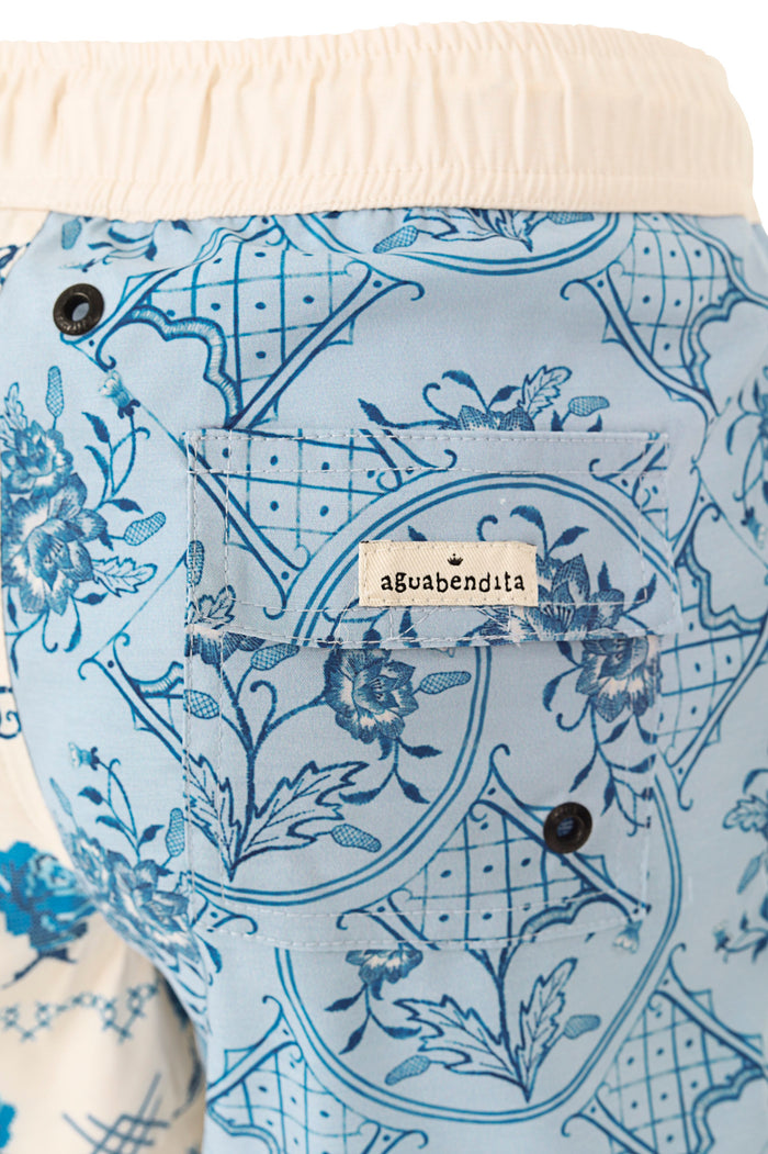 Light blue swim trunks with geometric lattice pattern and botanical illustrations in navy