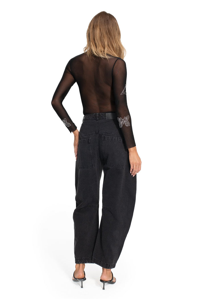 Black sheer bodysuit with long sleeves and rhinestone butterfly embellishments, back view, paired with wide-leg denim pants