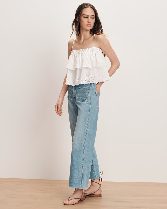 Veronica Beard White tiered ruffle camisole with light wash wide-leg jeans and black lace-up sandals.