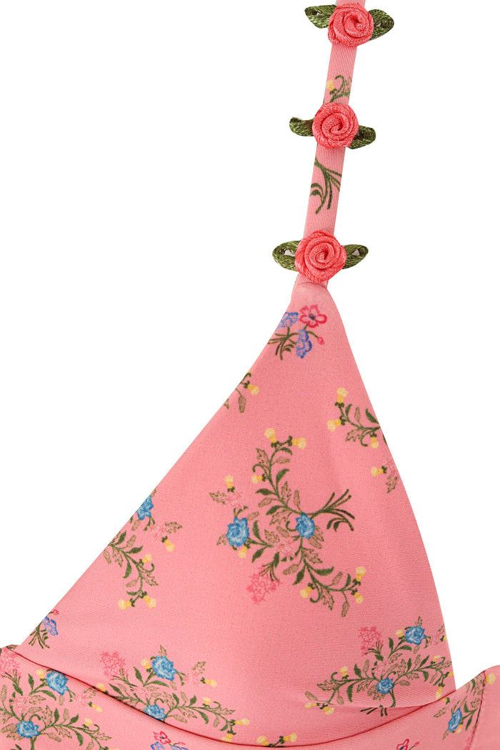 Pink bikini top with scattered pattern detail embroidery and three rosette flower appliqués with green leaves on strap