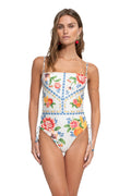 White one-piece swimsuit with vertical pinstripes, pattern detail and citrus fruit print, blue geometric trim, and side lace-up closures