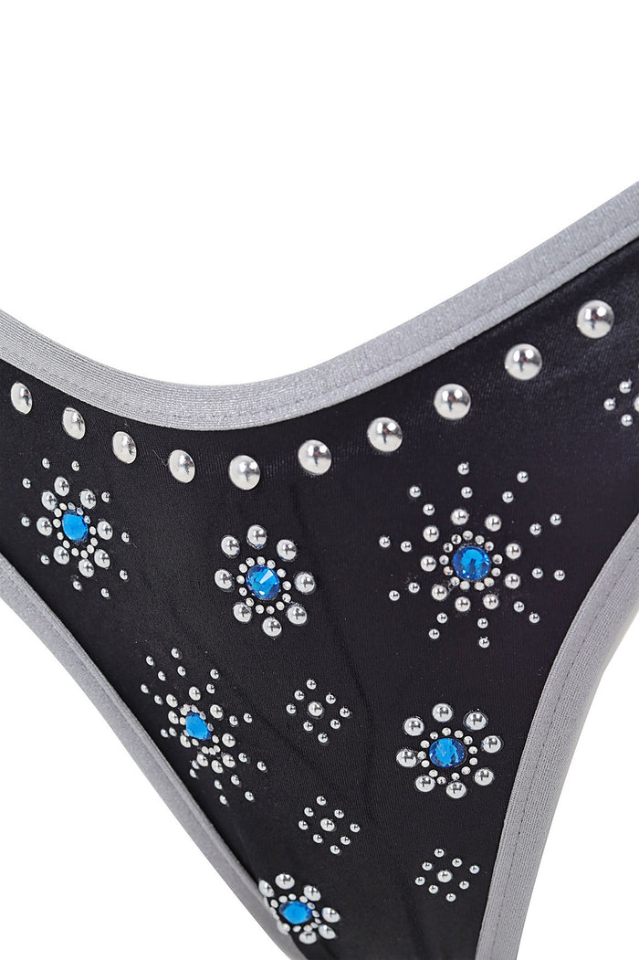 Black bikini bottom with gray trim, decorated with silver studs and turquoise rhinestone embellishments in a pattern detail pattern