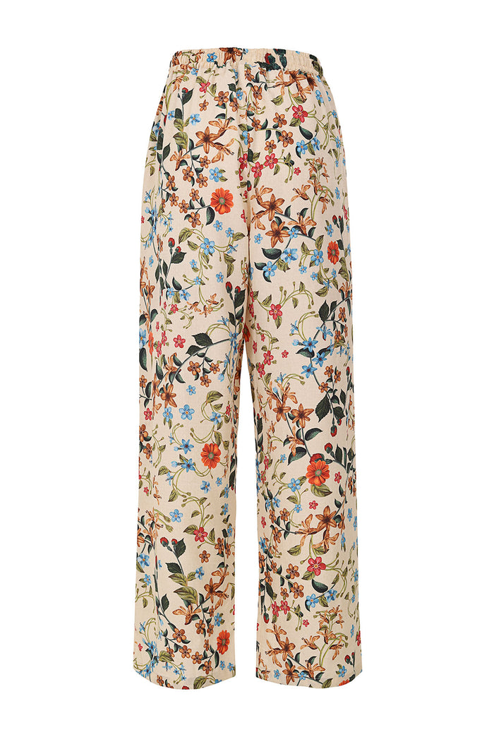 Wide-leg pants in cream with allover floral print featuring orange, blue, and pink blooms with green leaves and vines